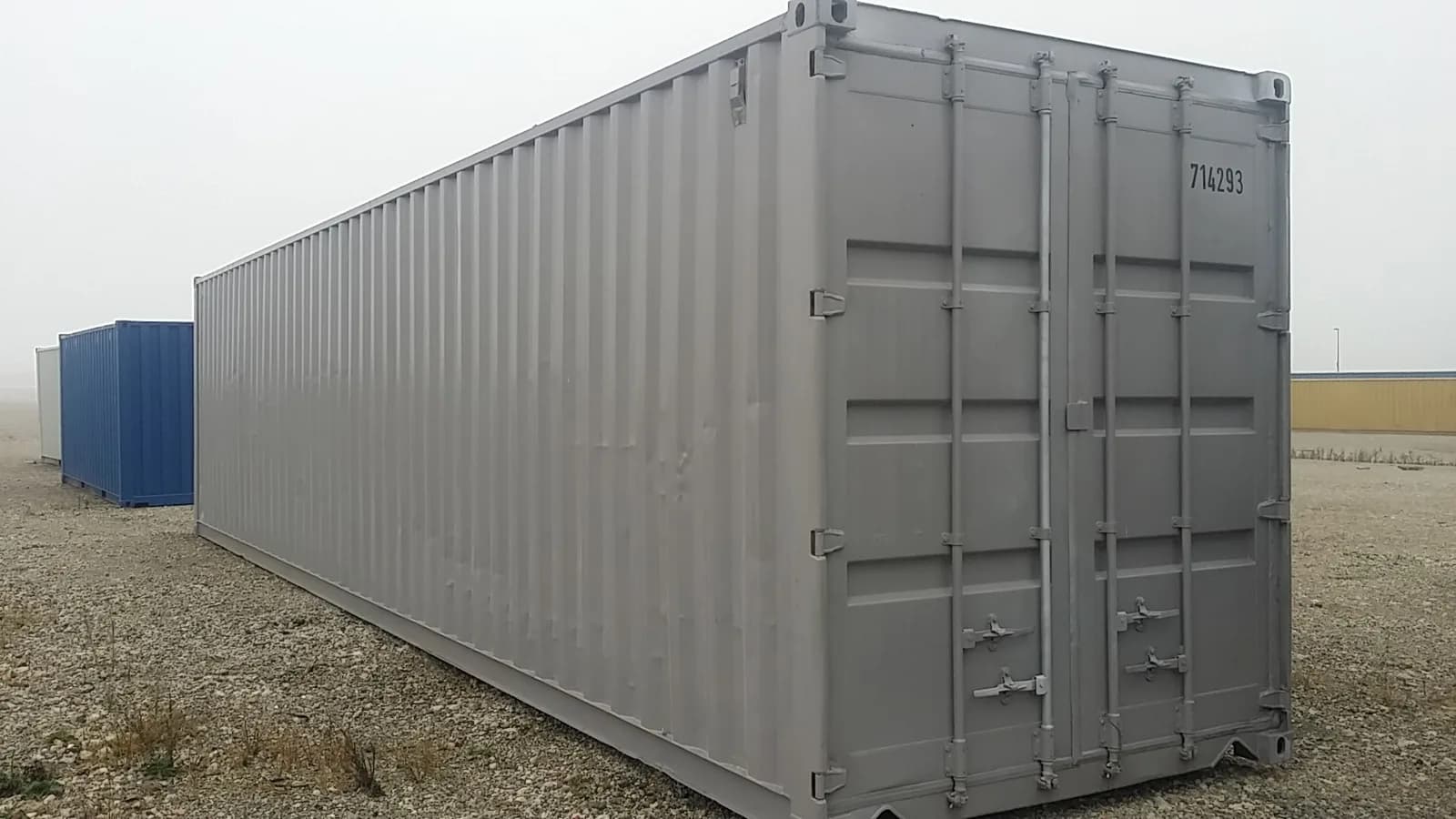 Gebrauchter 40-Fuß-Container in Grau mit geschlossenen Türen auf einem Containerplatz