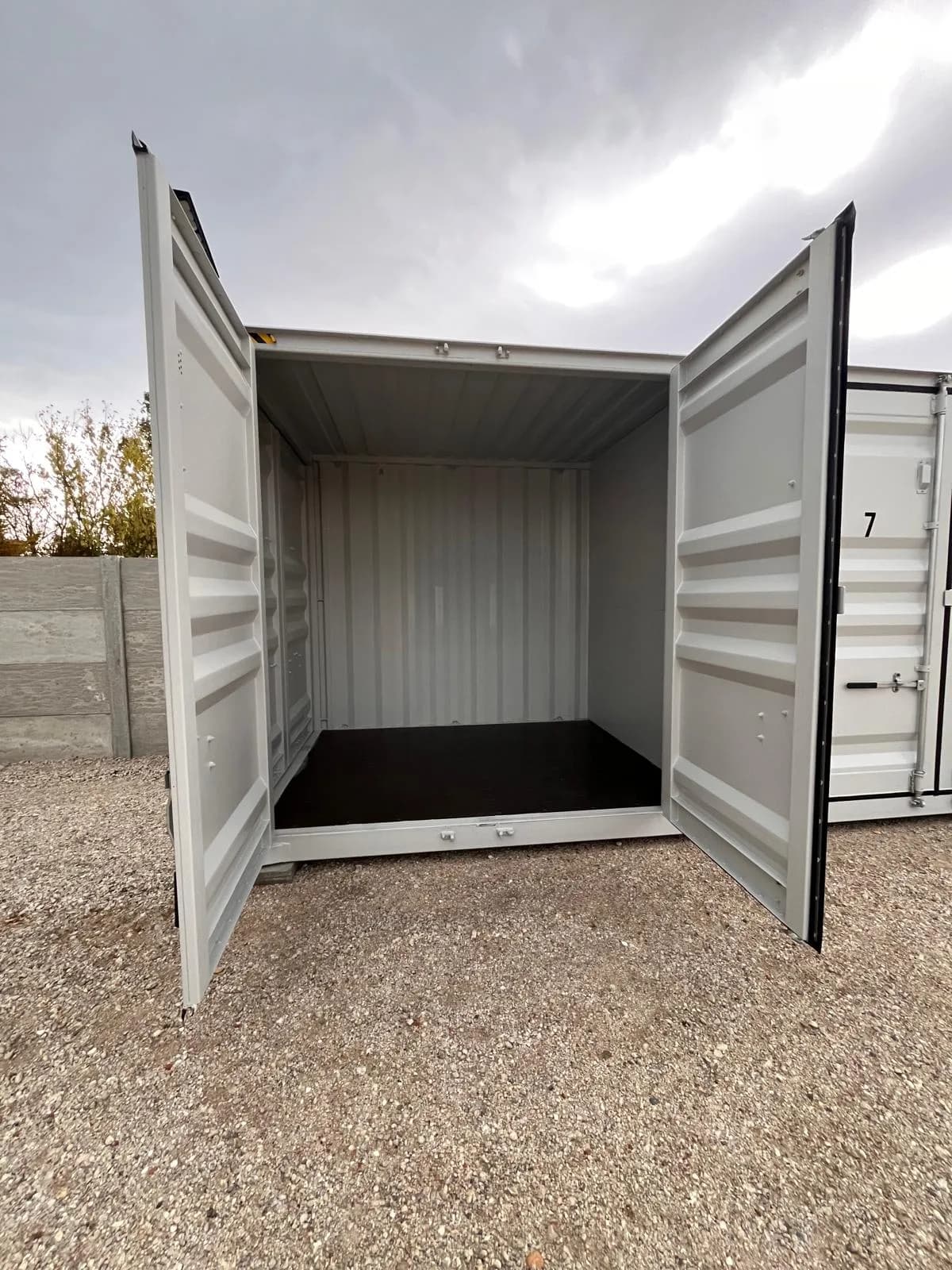 Geöffneter Container neben der Containerreihe