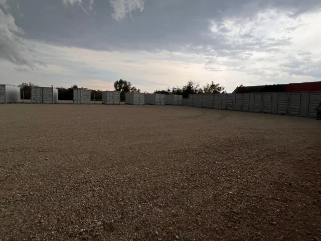 Geschotterter Platz der Anlage mit Containerreihe im Hintergrund