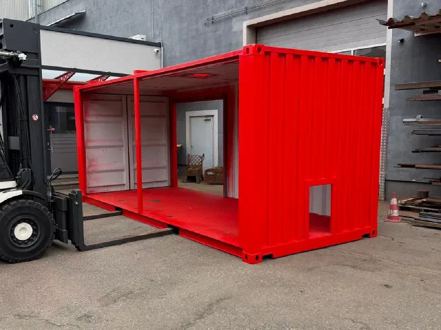 Rot lackierter 20-Fuß-Container mit offener Längsseite am Stapler vor der Werkhalle