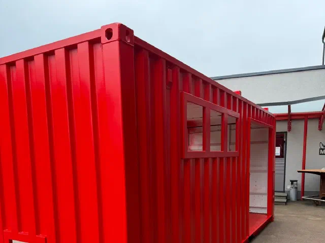 Seitenansicht des roten Containers mit Fensterband, Türöffnung und Durchgang